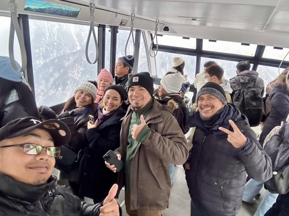 Gemaima Dumdum and group on a snowy mountain cable car